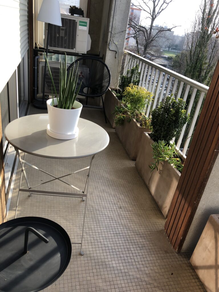 Aménagement d’un balcon avec des jardinières et pots fleuris.